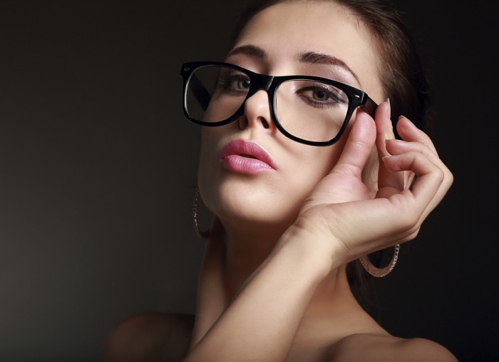 Sexy woman looking hot on modern glasses on dark background