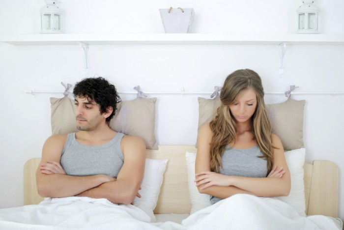 angry and unhappy young couple in bed