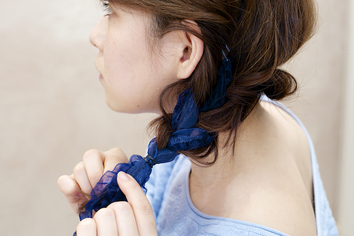 ロープ状にねじった毛束を2つの結び目の周りに巻きつける。