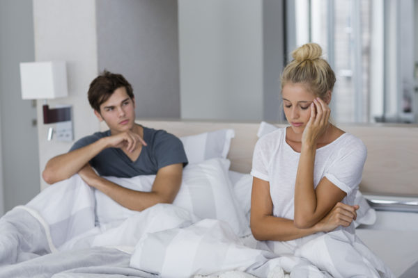 Young couple sitting on the bed with relationship difficulties