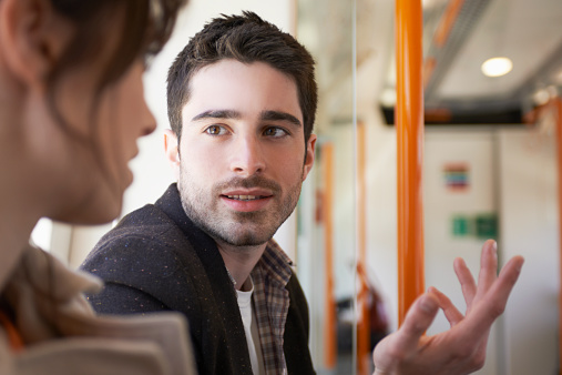 man talking to woman in train