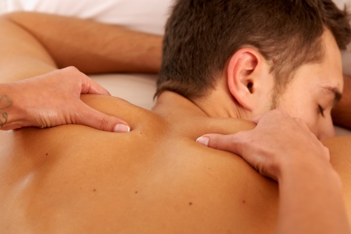 Woman’s hands massaging a man’s shoulders, close-up