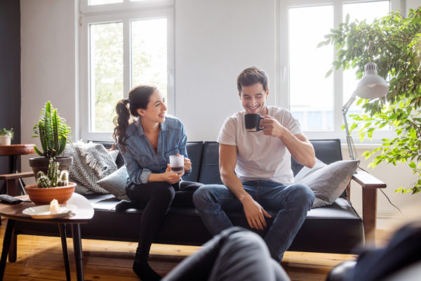 Couple having coffee together in living room