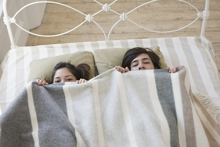Couple hiding in bed