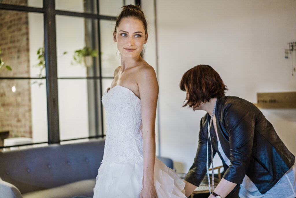 Designer is lifting wedding gown worn by customer