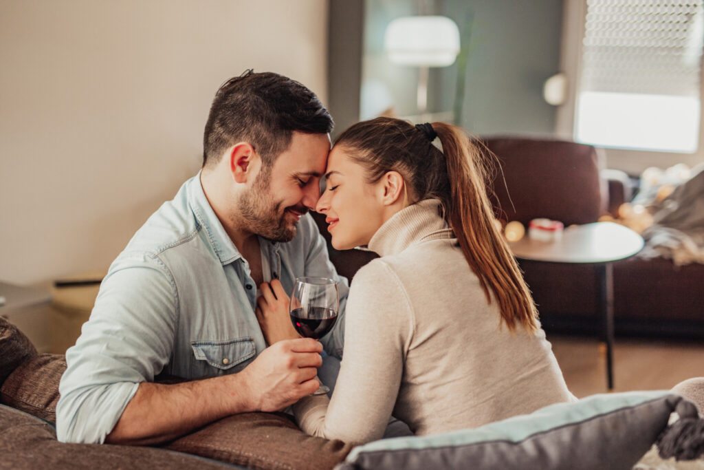 Young couple in love drinking wine at home