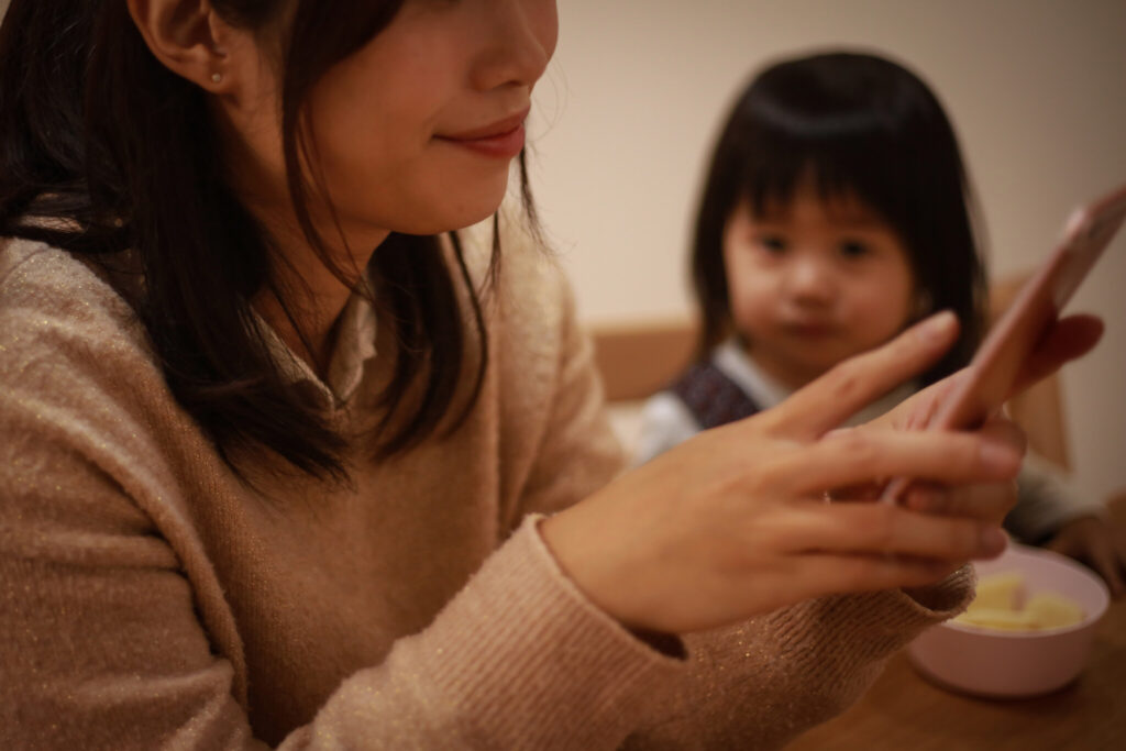 A mother who is absorbed in operating a smartphone