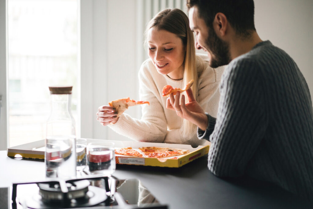 Couple eating takeaway pizza
