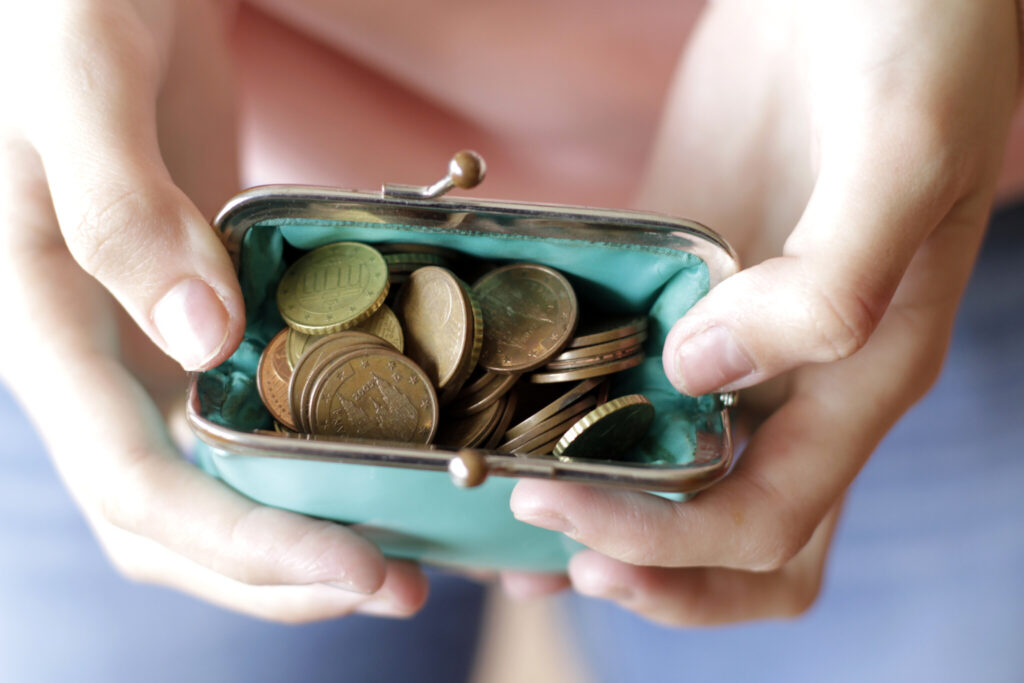 Woman holding purse full of coins