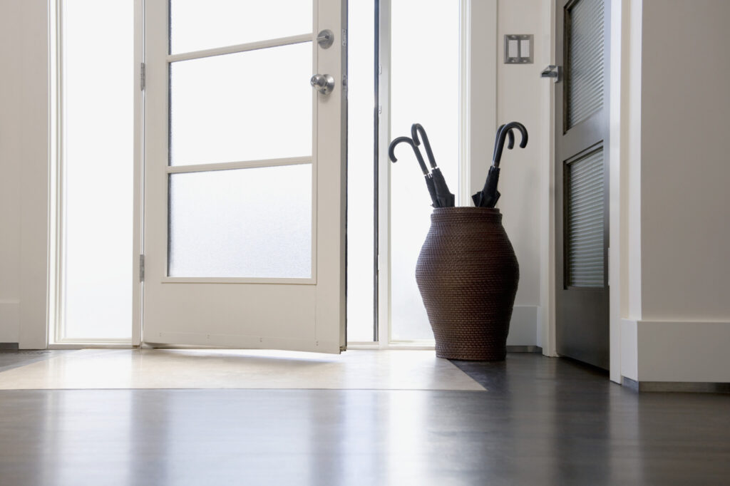 Front door with umbrellas in large vase