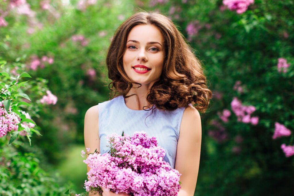 Young girl stand at park background with bouquet of flowers