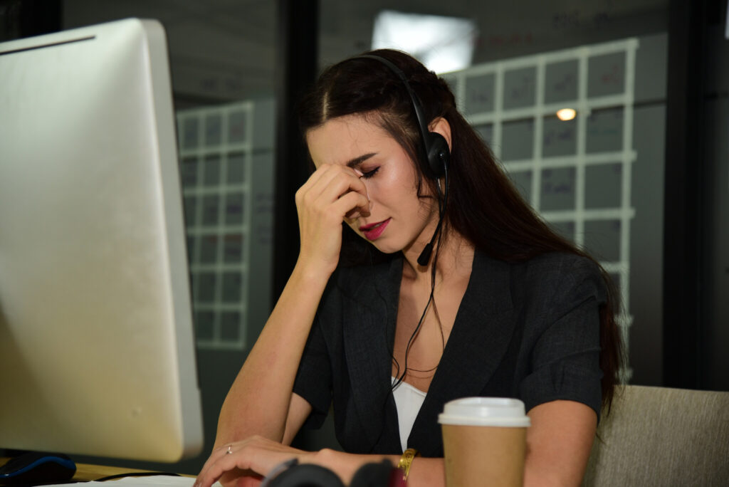 Woman in headphone work as operator of call centre feeling stress