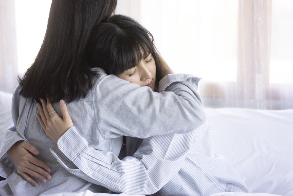 asian female feeling down and Consoling each other on cozy bedroom