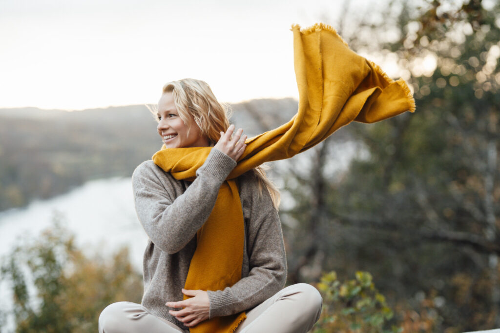 Smiling woman looking away wearing scarf during autumn