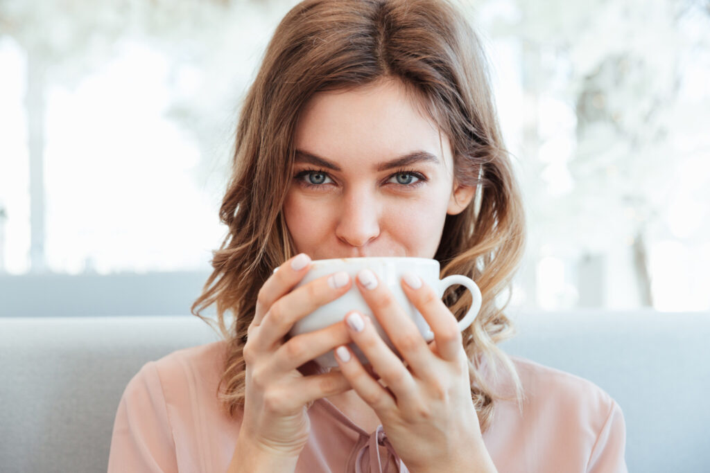 Portrait of a lovely young woman holding cup of coffee