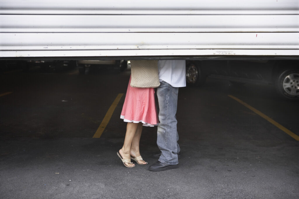 Couple Kissing Behing Garage Doors