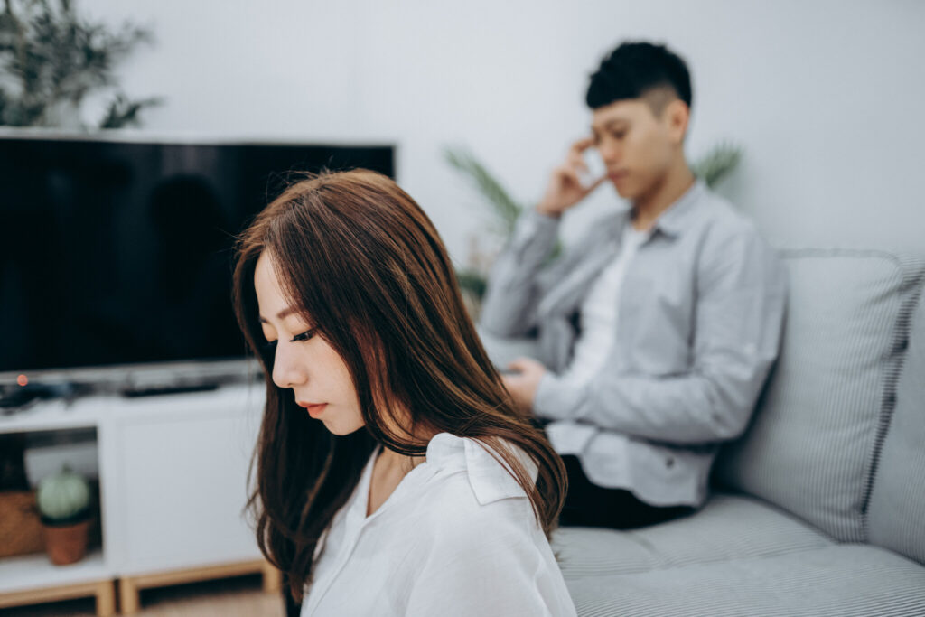 Young Asian couple using smartphone for entertainment during self isolation in Covid-19 health crisis