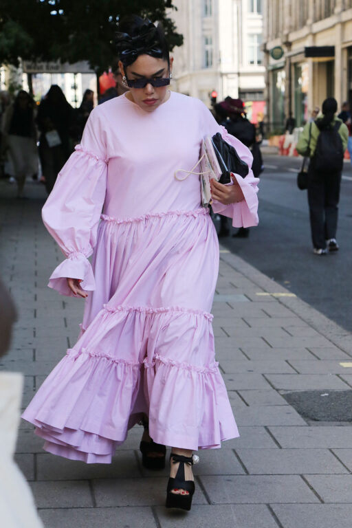 ふんわりとしたベビーピンクのワンピースを着た女性