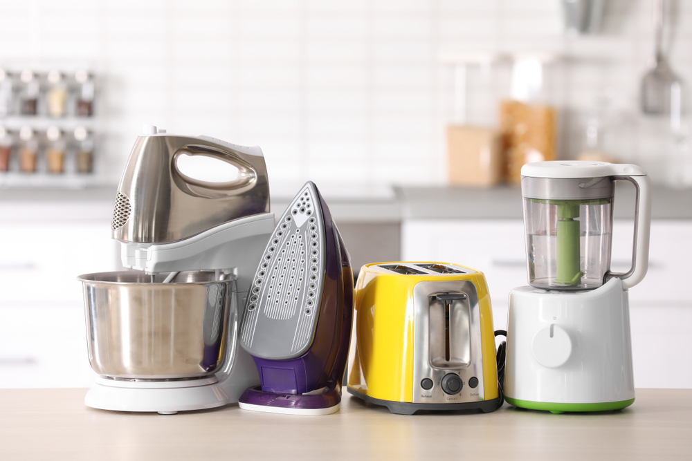 Household,And,Kitchen,Appliances,On,Table,Against,Blurred,Background