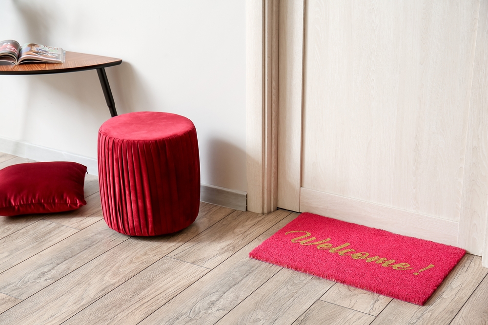 Stylish,Pouf,And,Mat,Near,Wooden,Door,In,Hall