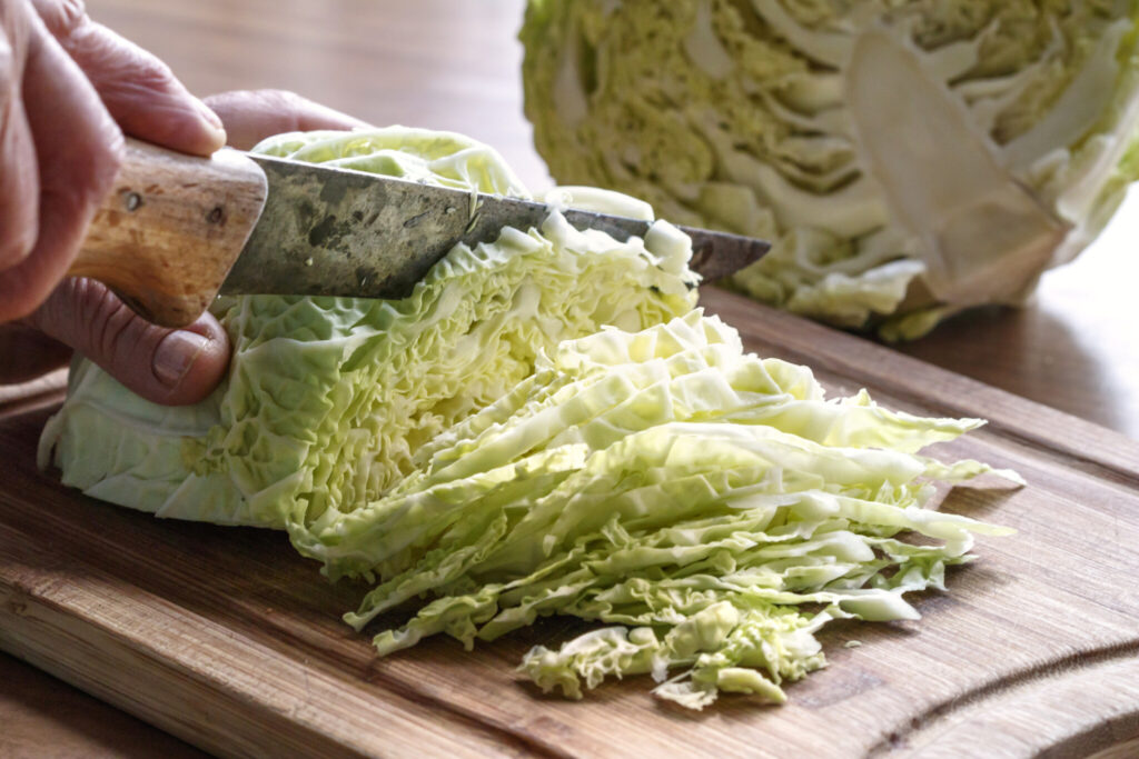 Cabbage being sliced with old knife